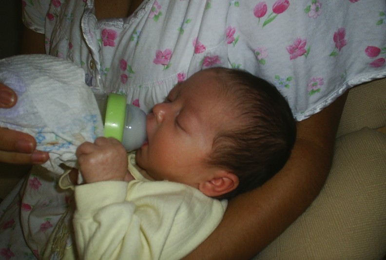 In mummy's arms drinking my tea.